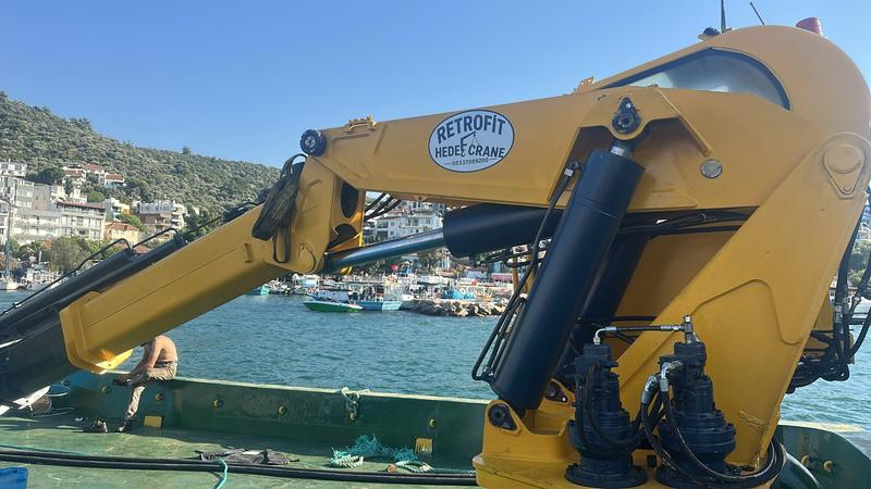 Limanda bir teknenin güvertesine bağlı, Retrofit Hedef Crane etiketli sarı katlanır bomlu vinç